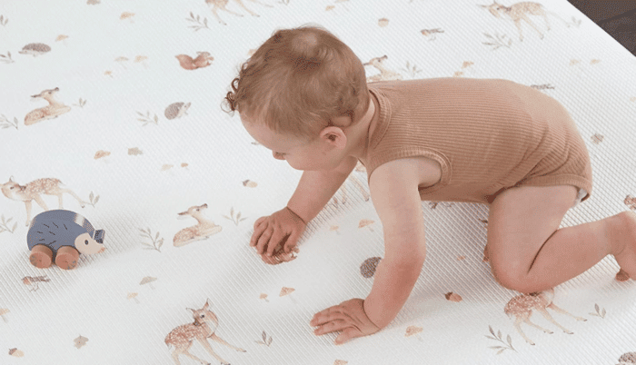 enfant jouant sur un tapis d'éveil Montessori