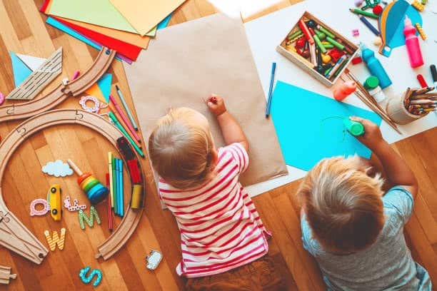 2 enfants avec des jouets éducatifs et des fournitures scolaires pour la créativité Montessori