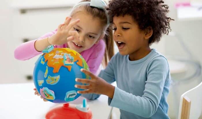 Deux enfants jouant un globe Montessori