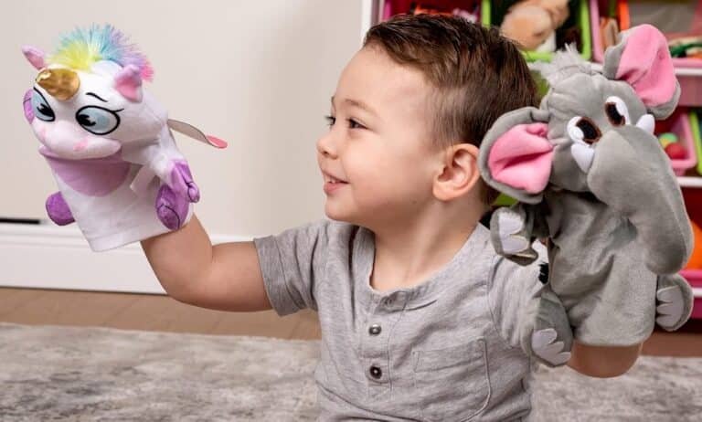 Un garçon jouant avec deux marionnettes animales
