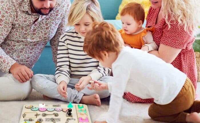Une famille jouant un panneau sensoriel