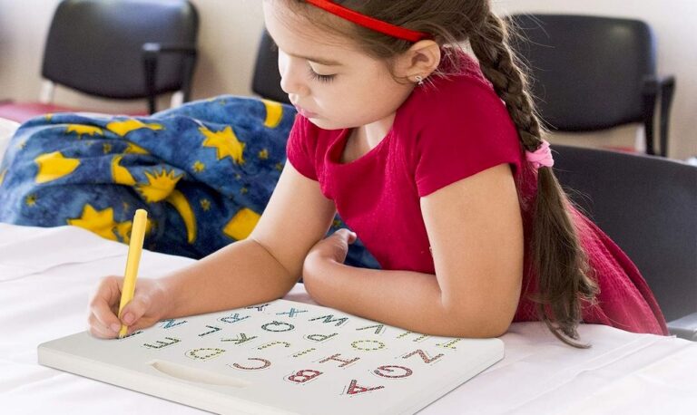 Une petite fille écrivant sur une tablette d'écriture Montessori