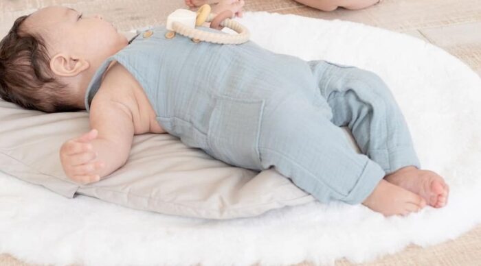Un bébé allongé sur un topponcino Montessori