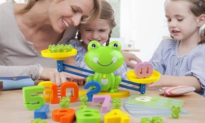 Mère et ses filles jouant une balance Montessori