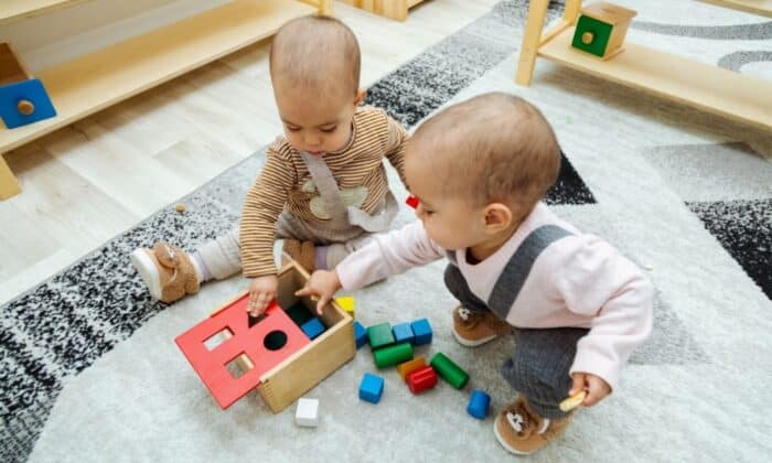 Deux enfants jouant une boîte de fermeture Montessori