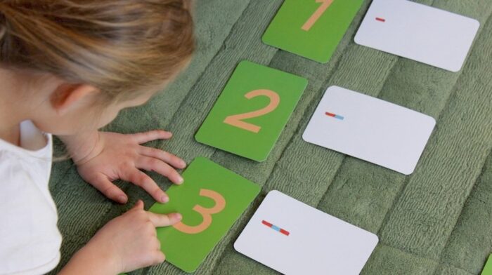 Une petite fille qui apprend à écrire avec des chiffres rugueux.