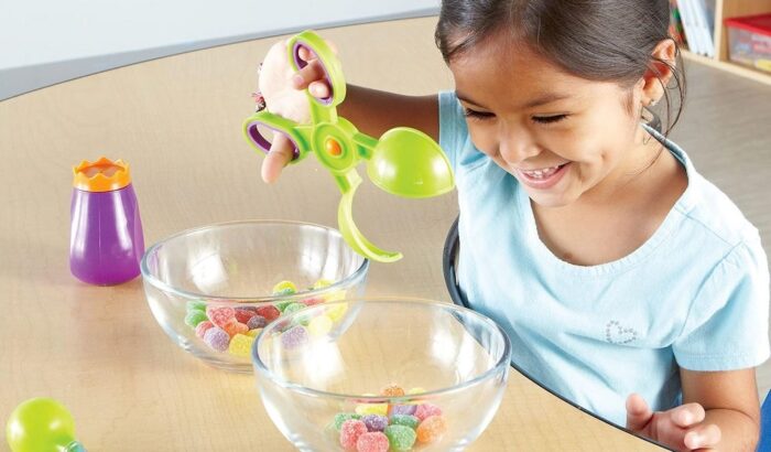 Une petite fille tenant un ciseau montessori