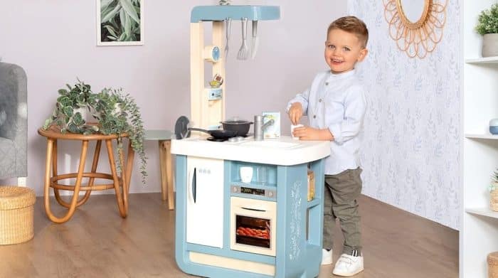 Un petit garçon préparant le repas dans une cuisine Montessori