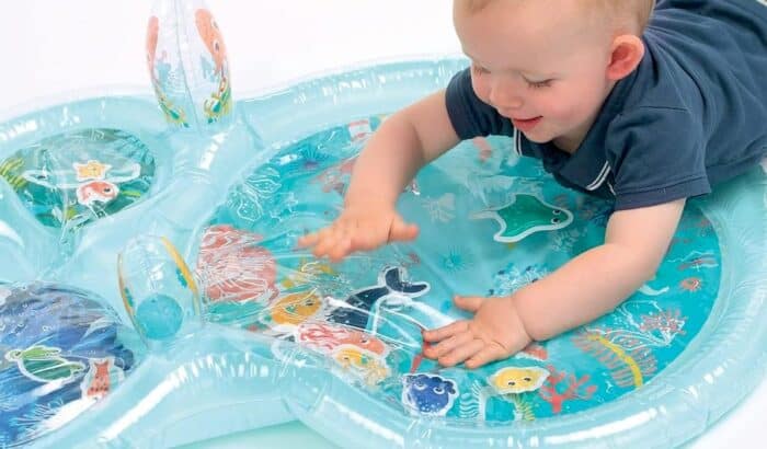 Un bébé touchant un tapis sensoriel