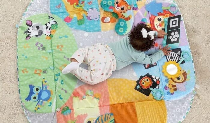 Un bébé jouant sur son tapis sensoriel
