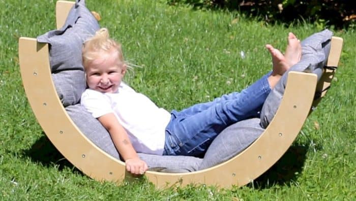 Un enfant allongé sur un bascule Montessori