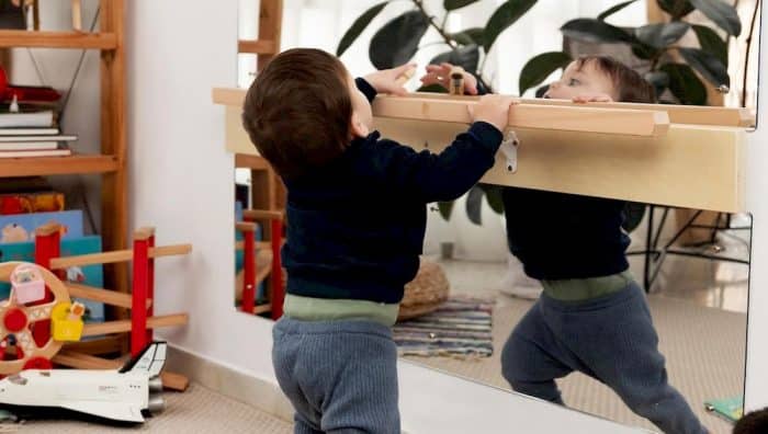 Un enfant devant un miroir incassable